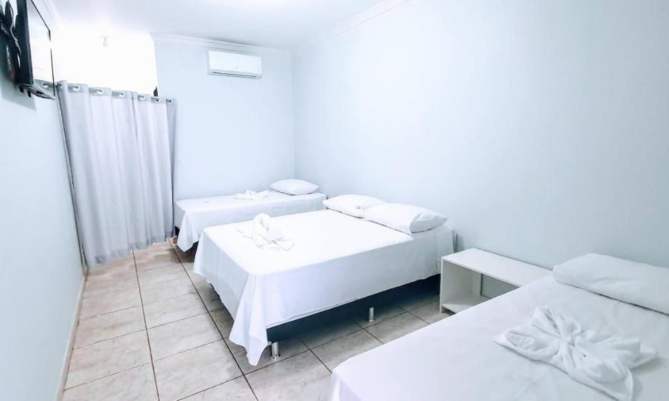 Quarto Família com camas arrumadas e ar-condicionado